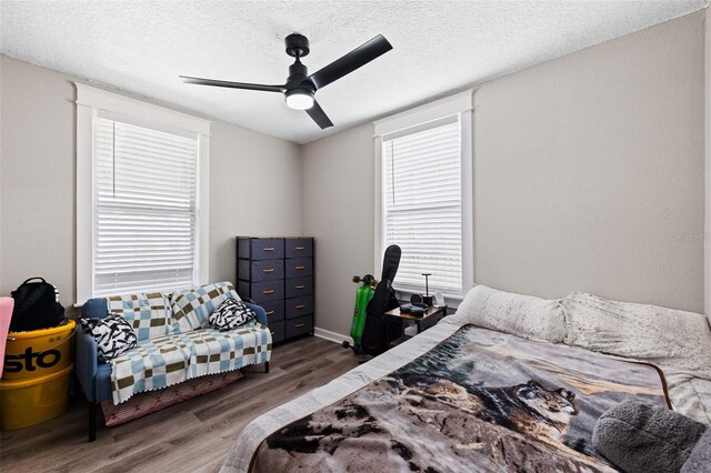 bedroom featuring a textured ceiling, wood-type flooring, and ceiling fan