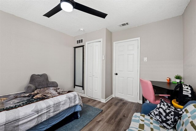 bedroom featuring a textured ceiling, ceiling fan, dark hardwood / wood-style floors, and a closet