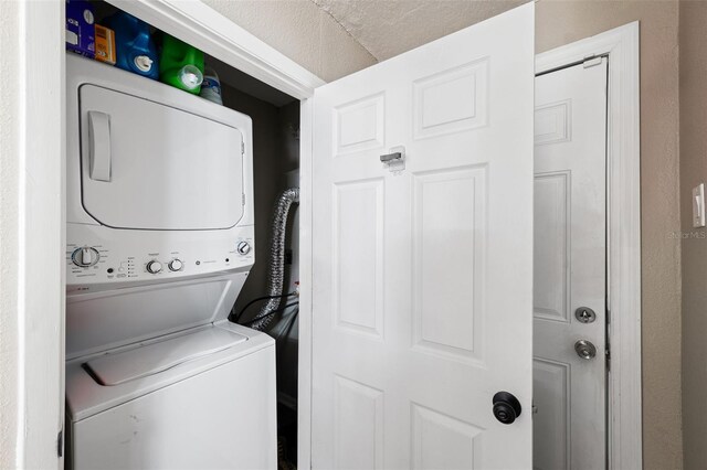 laundry area featuring a textured ceiling and stacked washer and dryer