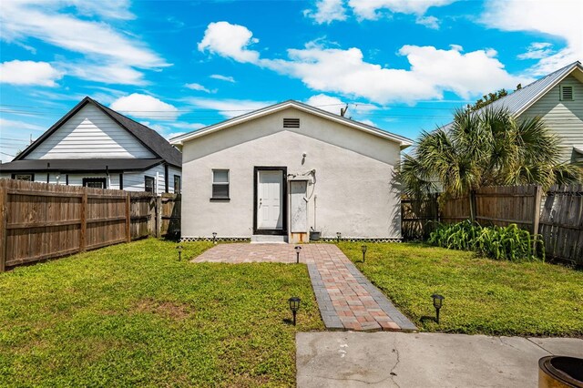 rear view of property with a yard