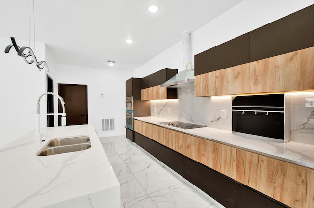 kitchen featuring black electric stovetop, light stone countertops, tasteful backsplash, and sink