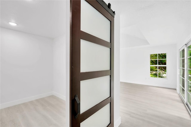 interior space featuring light wood-type flooring and a barn door