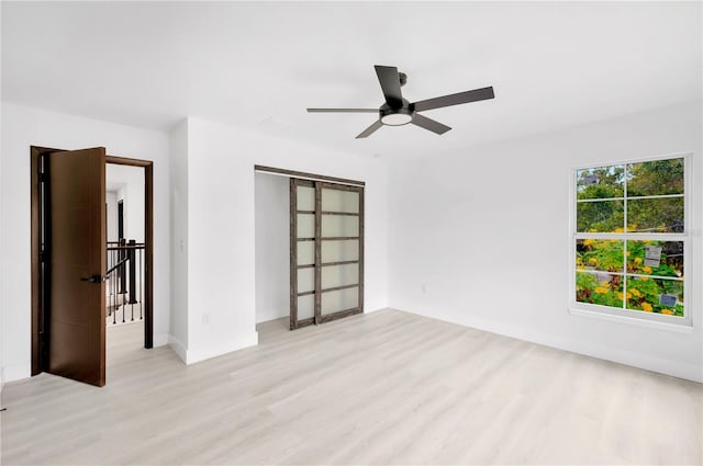 spare room featuring light hardwood / wood-style flooring and ceiling fan