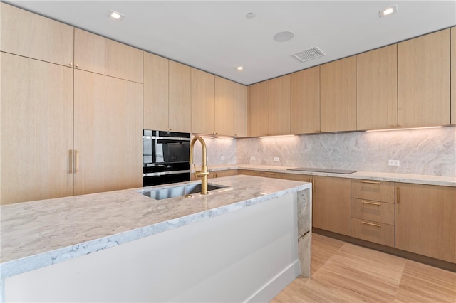 kitchen with light brown cabinetry, sink, and tasteful backsplash