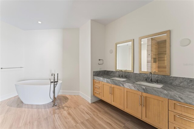 bathroom with vanity, a bathing tub, and hardwood / wood-style flooring