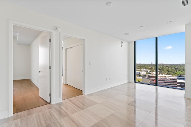 empty room featuring light hardwood / wood-style floors and floor to ceiling windows