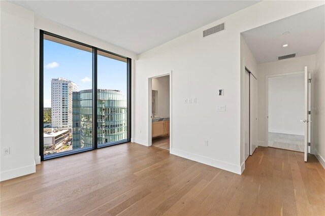 spare room with light hardwood / wood-style floors and a healthy amount of sunlight