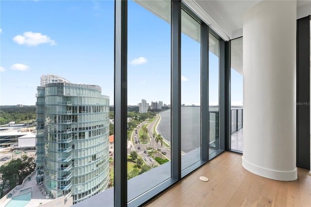 doorway to outside featuring hardwood / wood-style floors, a water view, and expansive windows