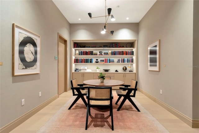 dining area with an inviting chandelier and built in shelves