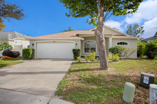 ranch-style house featuring a front yard and a garage