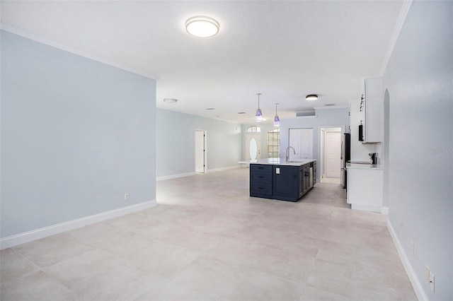 interior space featuring open floor plan, light countertops, ornamental molding, and a sink