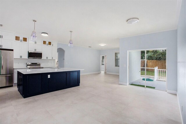 kitchen with decorative light fixtures, a center island with sink, appliances with stainless steel finishes, sink, and white cabinetry