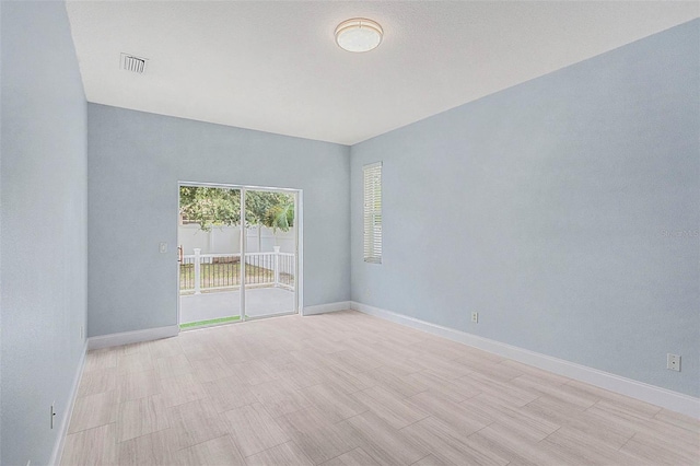 unfurnished room featuring visible vents and baseboards