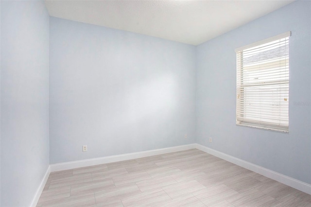 empty room with a wealth of natural light and light hardwood / wood-style flooring