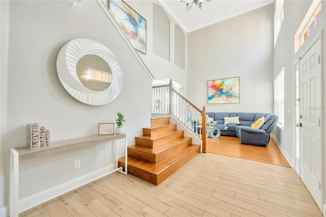 foyer featuring a towering ceiling and light hardwood / wood-style floors