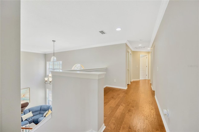 hallway with light hardwood / wood-style floors and crown molding