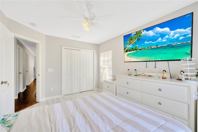 unfurnished bedroom with ceiling fan, a closet, and light hardwood / wood-style flooring