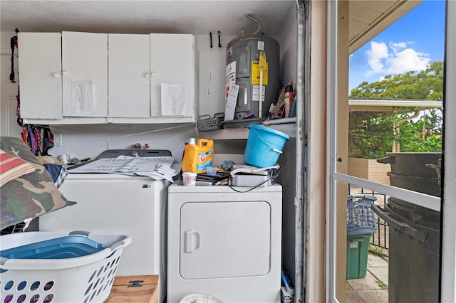 laundry area featuring cabinets, independent washer and dryer, and electric water heater