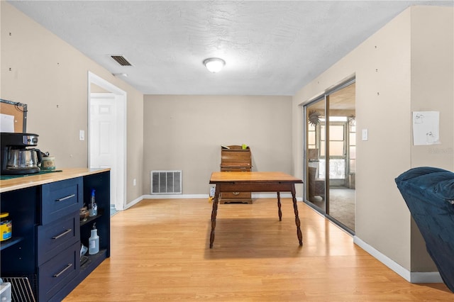 office featuring a textured ceiling and light hardwood / wood-style flooring