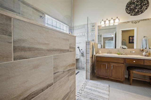 bathroom with vanity, a tile shower, and tile patterned floors