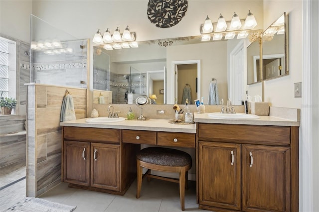 bathroom featuring tile patterned floors, tile walls, vanity, and a shower with shower door