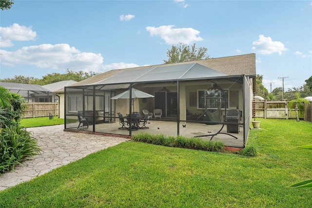 back of property featuring a yard, a lanai, and a patio area