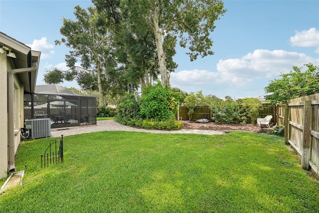 view of yard with glass enclosure and central AC