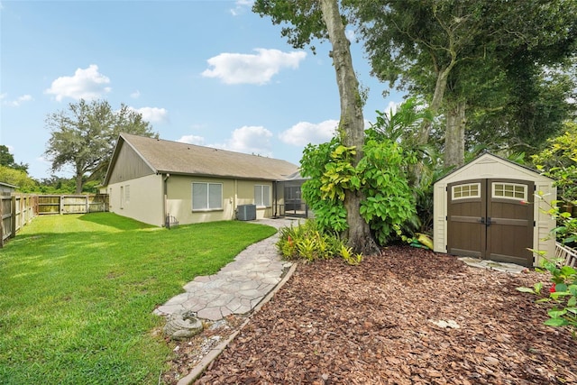 back of house featuring a yard, cooling unit, and a storage unit