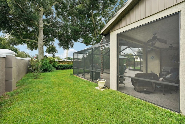 view of yard with ceiling fan, a lanai, and a patio