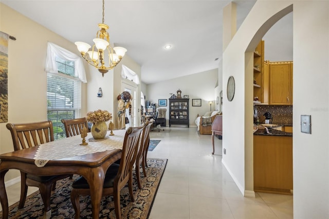 tiled dining space with a notable chandelier and vaulted ceiling