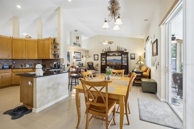 dining area with high vaulted ceiling, ceiling fan, sink, and light tile patterned flooring