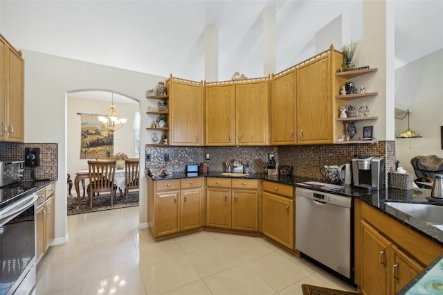 kitchen with an inviting chandelier, light tile patterned floors, stainless steel appliances, decorative backsplash, and dark stone counters