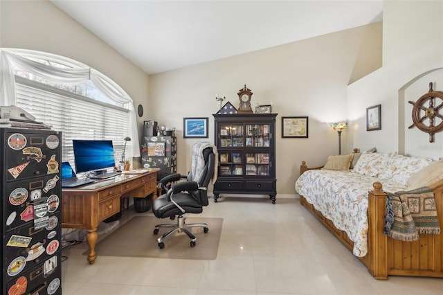 office space featuring light tile patterned floors and vaulted ceiling