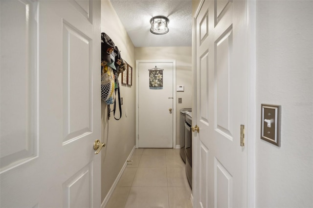 entryway with a textured ceiling and light tile patterned flooring