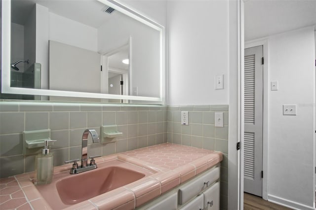 bathroom featuring vanity and backsplash