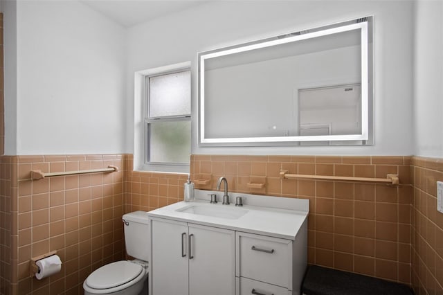 bathroom featuring toilet, tile walls, and vanity