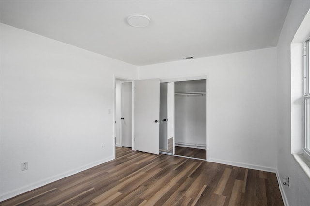 unfurnished bedroom featuring dark hardwood / wood-style floors and a closet