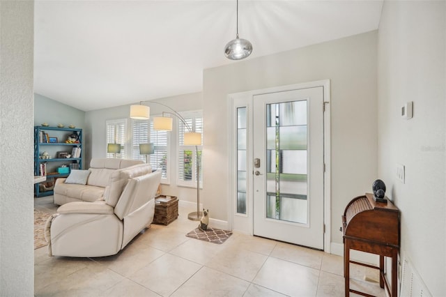 doorway with vaulted ceiling and light tile patterned floors