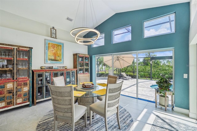 dining room featuring high vaulted ceiling, light tile patterned flooring, and a notable chandelier