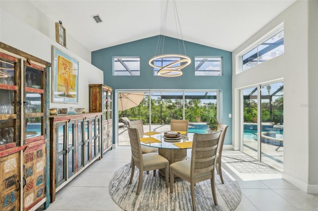 dining room featuring high vaulted ceiling, light tile patterned floors, and a chandelier