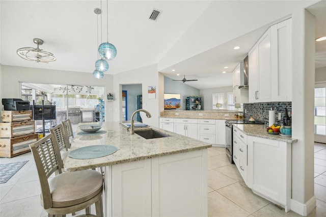 kitchen featuring plenty of natural light, vaulted ceiling, sink, and stainless steel electric stove