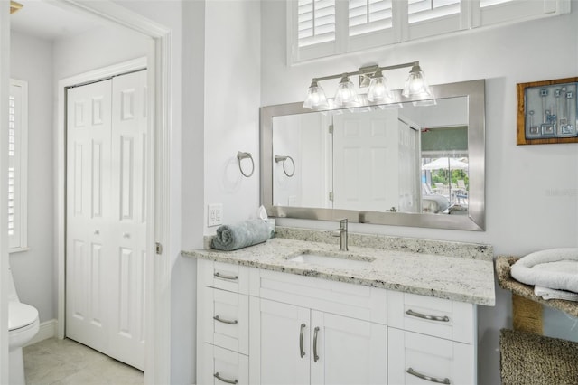 bathroom with tile patterned flooring, vanity, and toilet