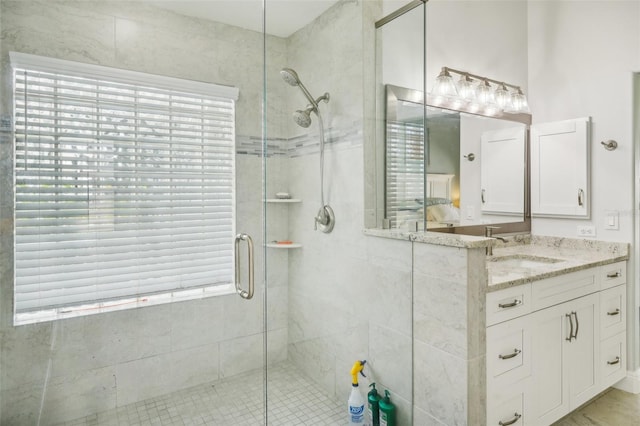 bathroom with a shower with door and vanity