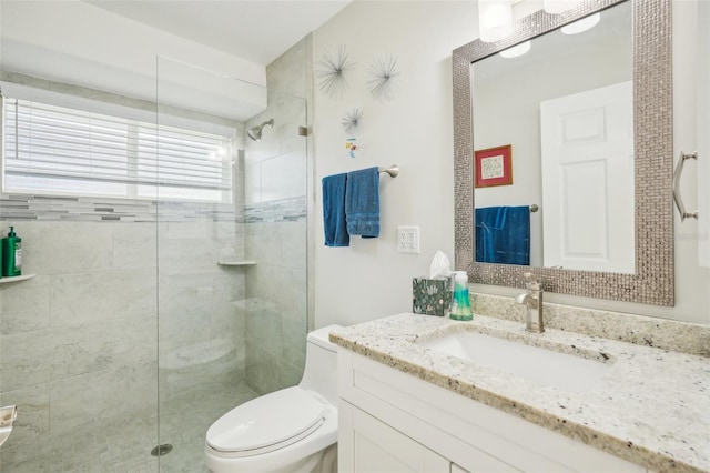 bathroom with a shower with shower door, toilet, and vanity