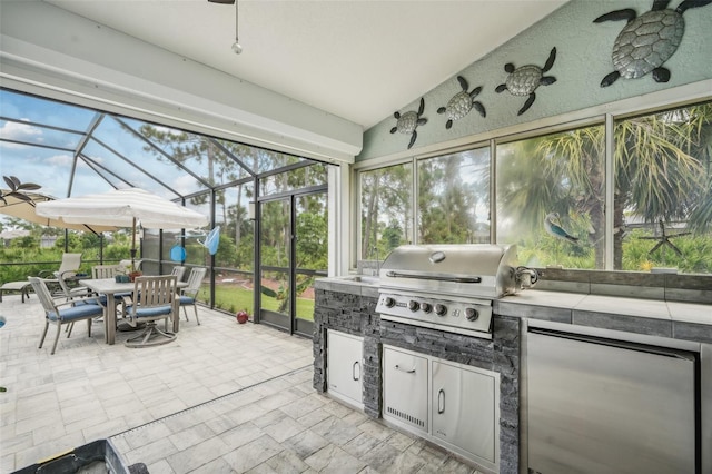 sunroom / solarium with a healthy amount of sunlight, ceiling fan, and vaulted ceiling