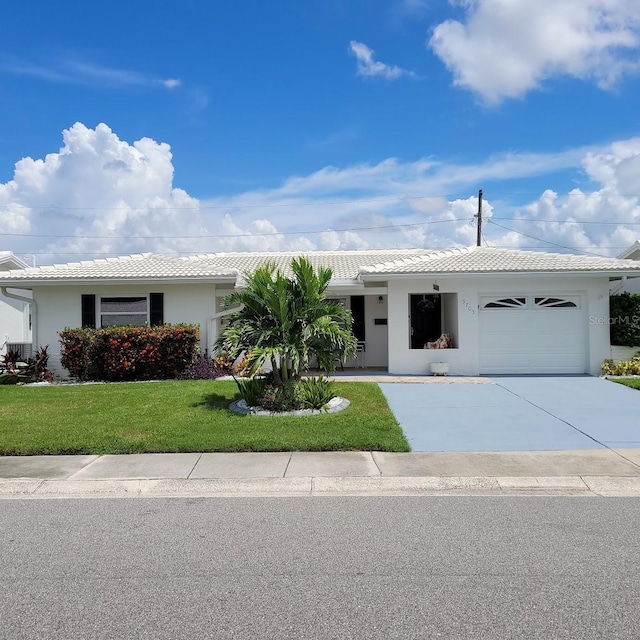 single story home featuring an attached garage, stucco siding, a front yard, and a tiled roof