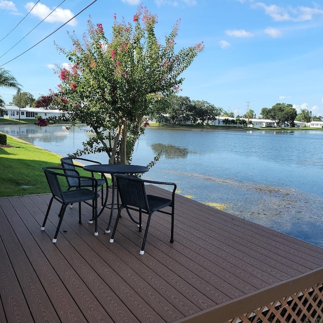 wooden deck featuring a water view and a yard