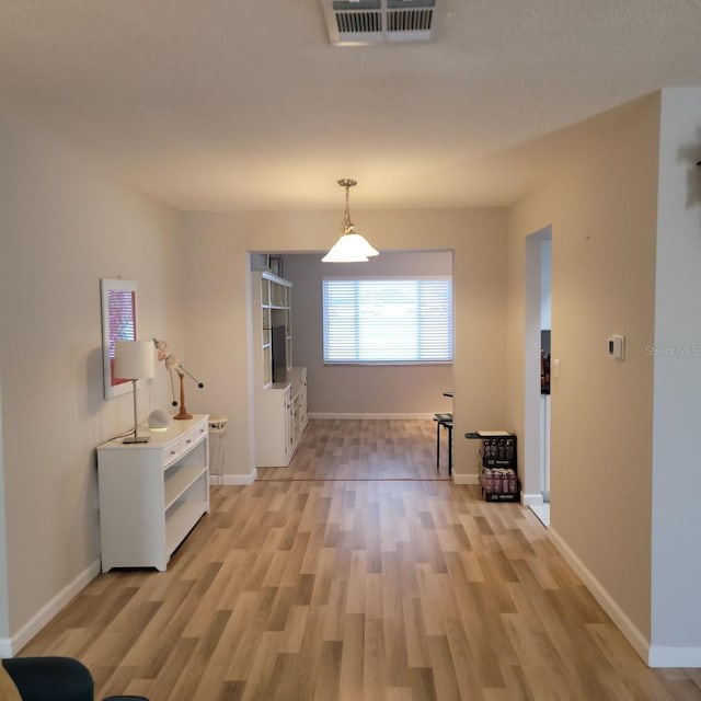 interior space with baseboards, visible vents, and light wood-style floors