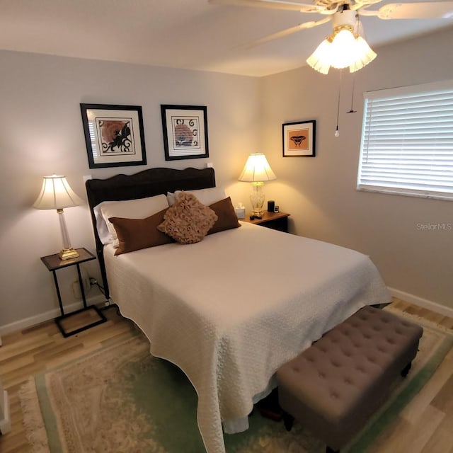 bedroom with light wood-style floors, baseboards, and a ceiling fan