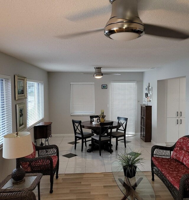 dining room featuring a ceiling fan, a textured ceiling, and baseboards